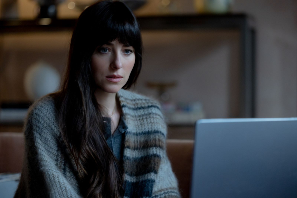 Dakota Johnson stars as Lowen Ashleigh in director Michael Showalter's VERITY. In this still Dakota sitsin front of a...